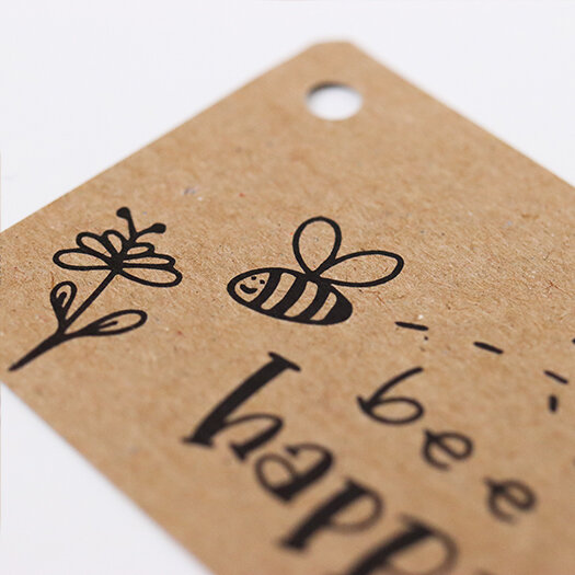 Sfeerfoto kraftlabel 50 x 60 mm met boorgat met de tekst &#039;bee happy&#039;