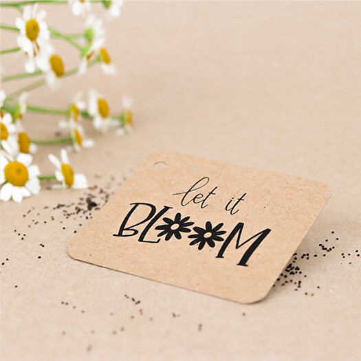 Sfeerfoto kraftlabel 50 x 60 mm met boorgat met de tekst &#039;Let it bloom&#039;